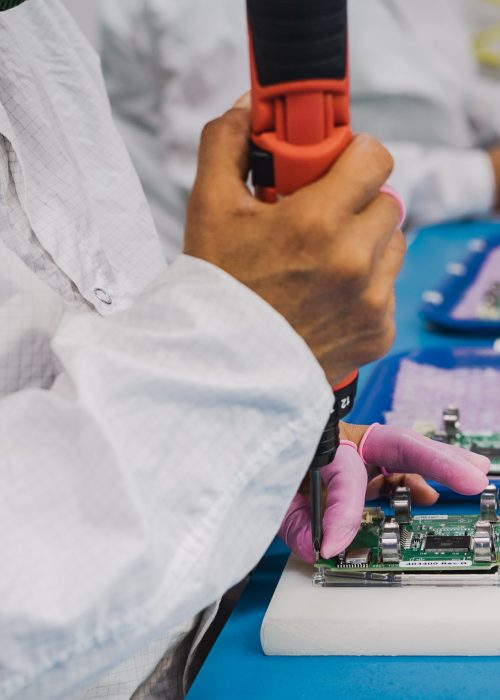 Precision Assembly in a Controlled Environment Technician assembling electronic components in a cleanroom environment with precise tools.