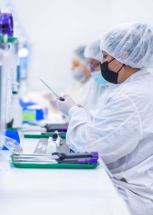 Cleanroom Technicians Assembling Medical Devices – LSO Manufacturing Technicians in cleanroom PPE assembling minimally invasive medical devices with precision and regulatory focus.