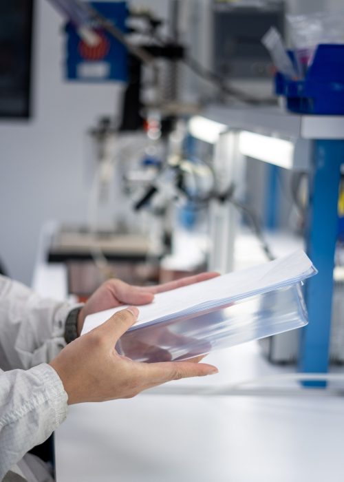 Sterile Medical Device Packaging Gloved hands holding a sterile medical device in clear packaging.
