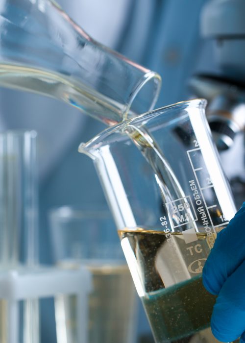 Male hand hold yellow liquid in test tube. Conveyor line production household cleaning products detergents help cleaning destruction stains pests urine poison antidote vaccine concept.